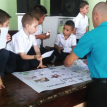 Niños alrededor de mesa trabajando en actividades del Proyecto escolar "Galardón de la Probidad"